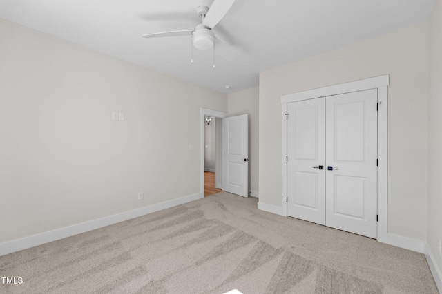 unfurnished bedroom with carpet floors, a closet, ceiling fan, and baseboards