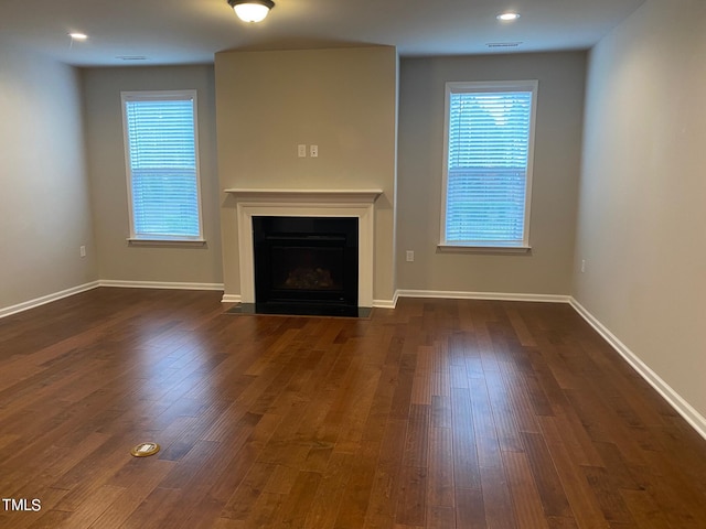 unfurnished living room with dark wood-type flooring