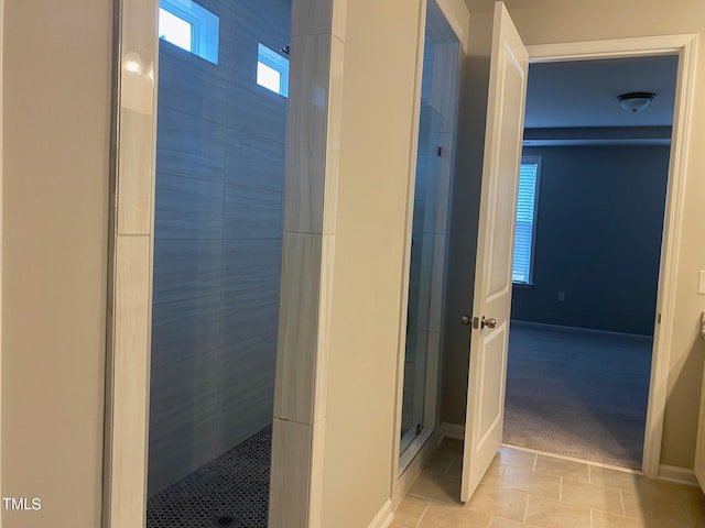 bathroom with tile patterned floors and a tile shower