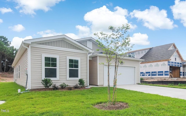 view of front of property featuring board and batten siding, a front lawn, driveway, and a garage