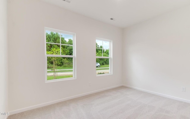 empty room with baseboards and light colored carpet