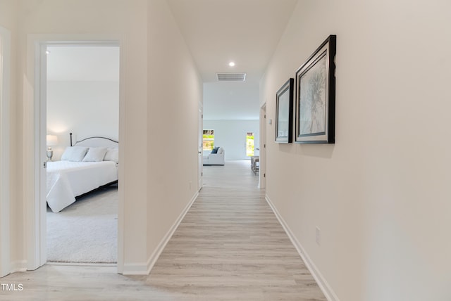 corridor with light wood-type flooring, baseboards, visible vents, and recessed lighting