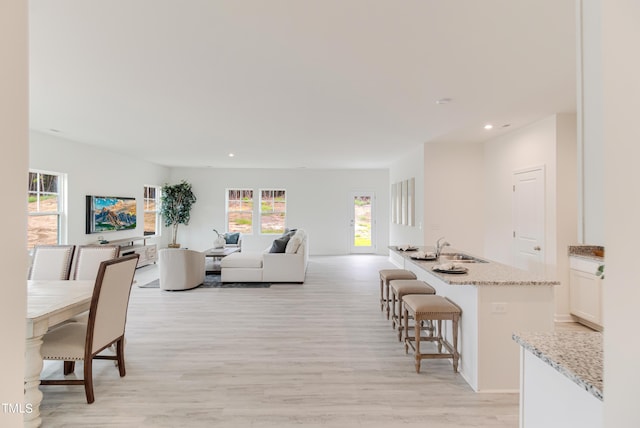 living area with light wood-type flooring and recessed lighting