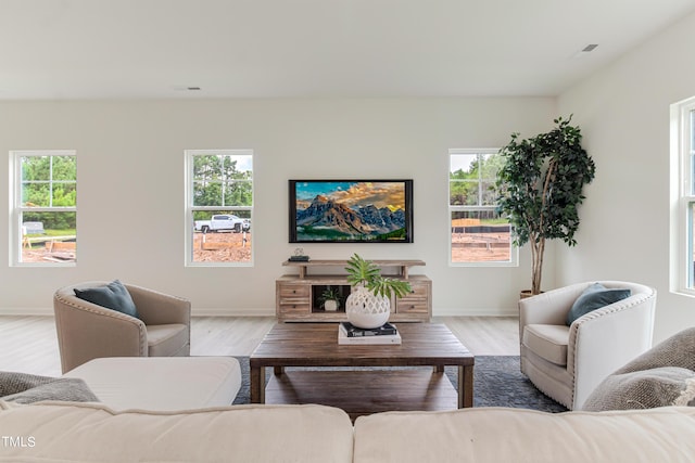 living area featuring baseboards, visible vents, and light wood-style floors