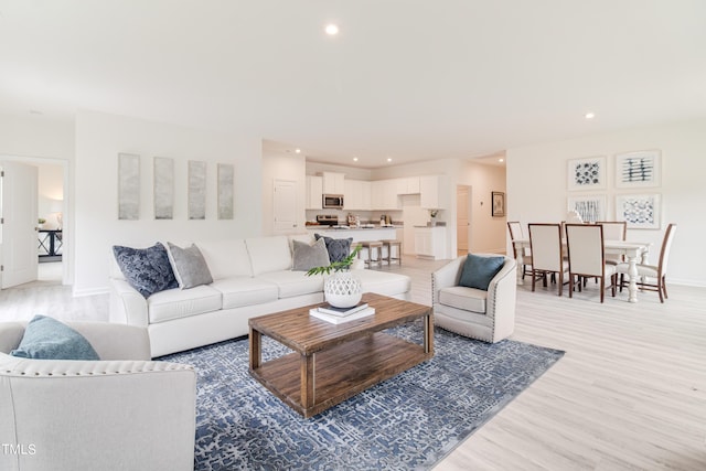 living area featuring recessed lighting, light wood-style flooring, and baseboards