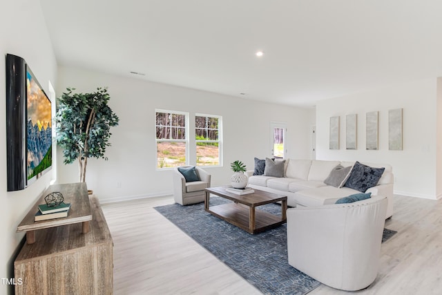 living room featuring visible vents, baseboards, and wood finished floors