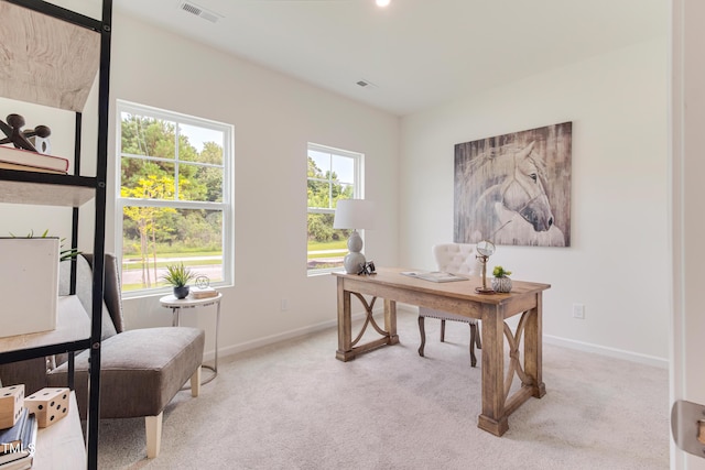 office featuring baseboards, visible vents, and light colored carpet