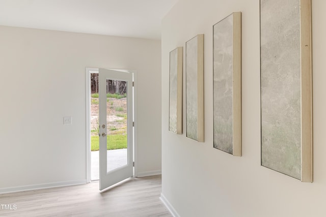 doorway with light wood-style flooring and baseboards