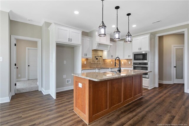 kitchen featuring dark hardwood / wood-style floors, oven, built in microwave, a kitchen island with sink, and light stone counters