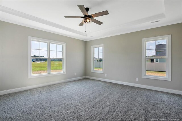 carpeted spare room featuring a tray ceiling, crown molding, and ceiling fan