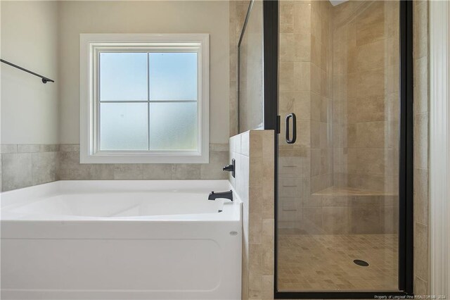 bathroom featuring shower with separate bathtub