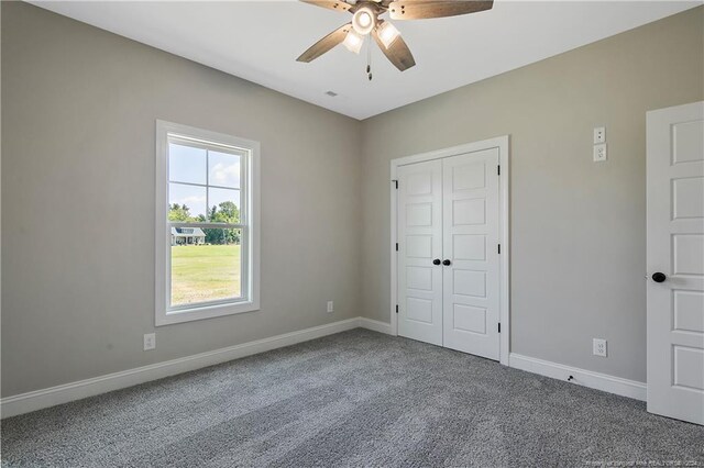 unfurnished bedroom featuring a closet, ceiling fan, and carpet flooring