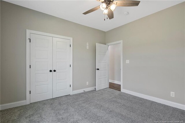 unfurnished bedroom featuring a closet, ceiling fan, and carpet