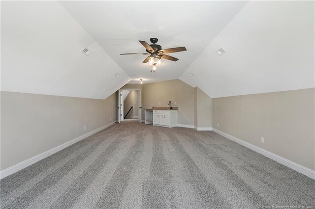 bonus room with vaulted ceiling, ceiling fan, and carpet flooring