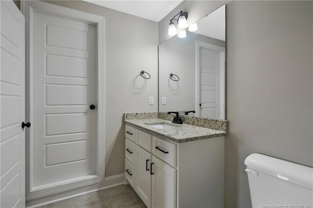 bathroom with vanity, toilet, and tile patterned floors