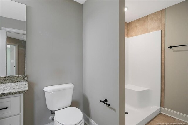 bathroom featuring vanity, toilet, tile patterned floors, and walk in shower