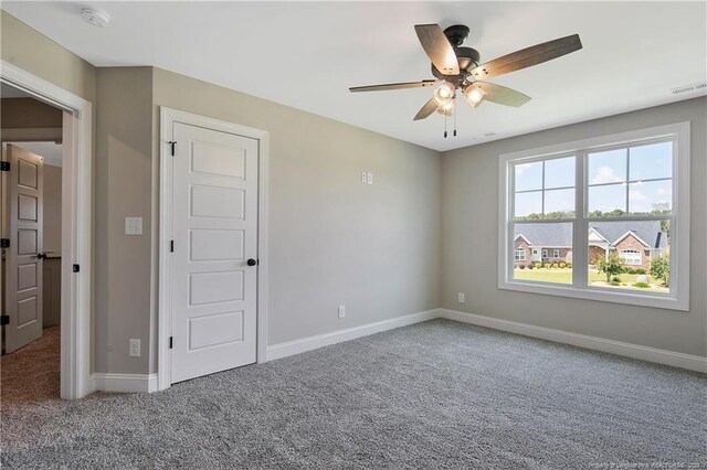 unfurnished room with ceiling fan and carpet