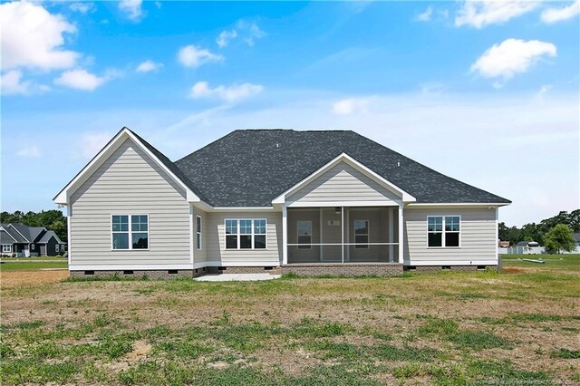 back of house featuring a sunroom and a lawn