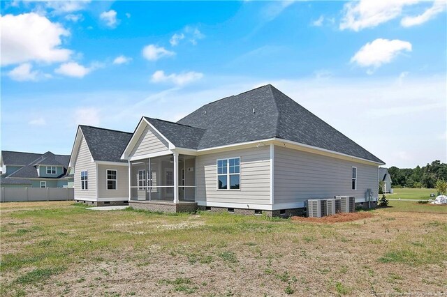 back of property with a sunroom and a yard