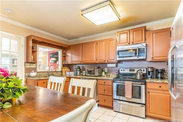 kitchen with crown molding, appliances with stainless steel finishes, and light tile patterned floors