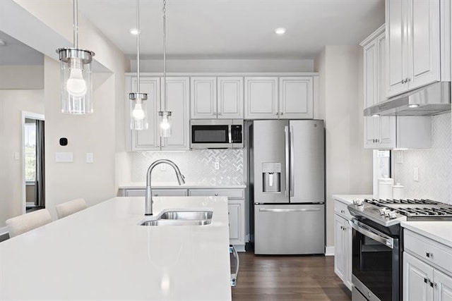 kitchen with sink, stainless steel appliances, pendant lighting, decorative backsplash, and white cabinets