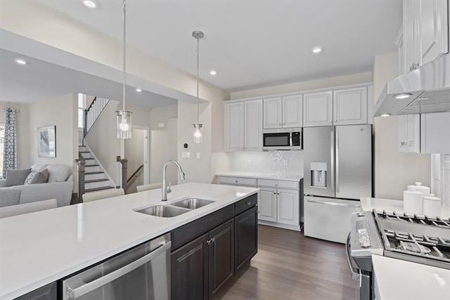 kitchen featuring stainless steel appliances, sink, decorative light fixtures, dark hardwood / wood-style floors, and white cabinetry