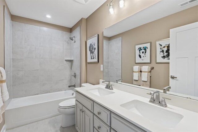 full bathroom with tile patterned flooring, vanity, toilet, and tiled shower / bath