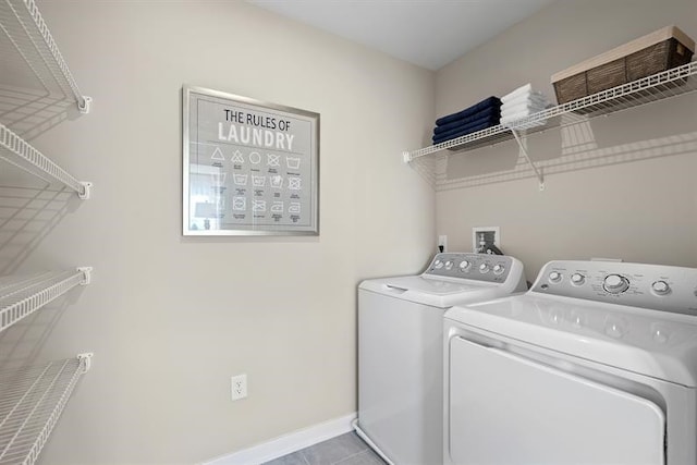 washroom with light tile patterned floors and washer and clothes dryer