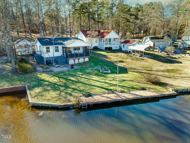 back of house with a lawn and a deck with water view