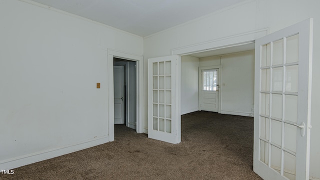 carpeted spare room featuring crown molding