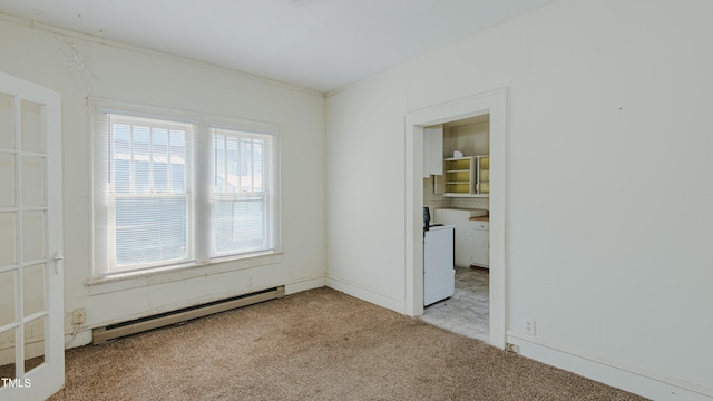 carpeted empty room featuring washer / clothes dryer, a baseboard heating unit, and ornamental molding