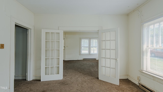 unfurnished room featuring crown molding, baseboard heating, and carpet flooring