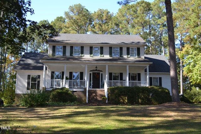 colonial inspired home with a porch and a front lawn