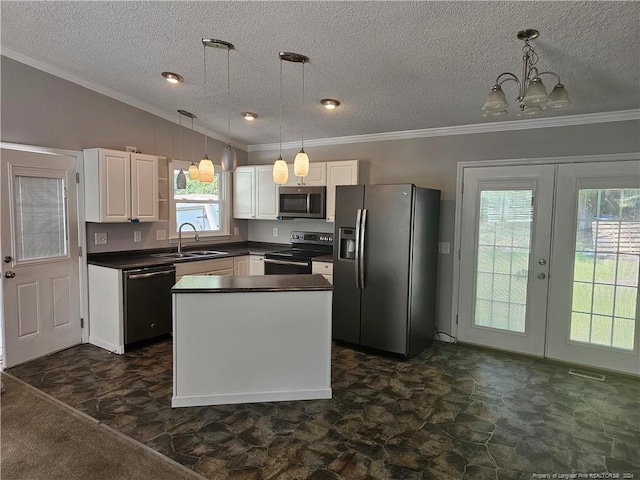 kitchen featuring lofted ceiling, a healthy amount of sunlight, appliances with stainless steel finishes, and a textured ceiling