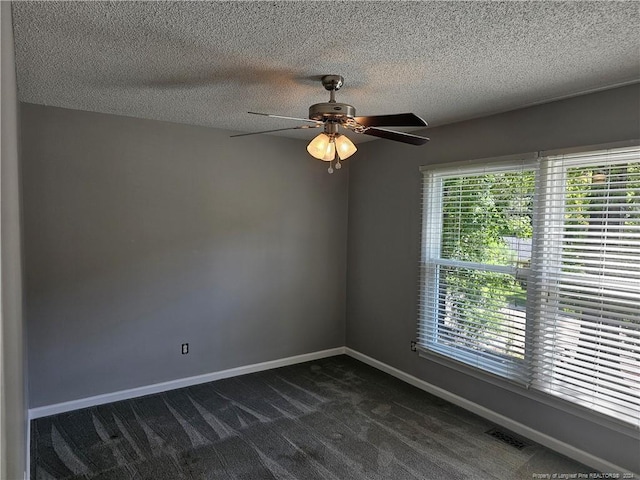 carpeted empty room with ceiling fan and a textured ceiling