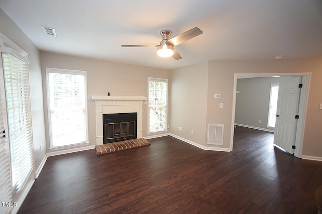 unfurnished living room with dark wood-type flooring, ceiling fan, plenty of natural light, and a fireplace