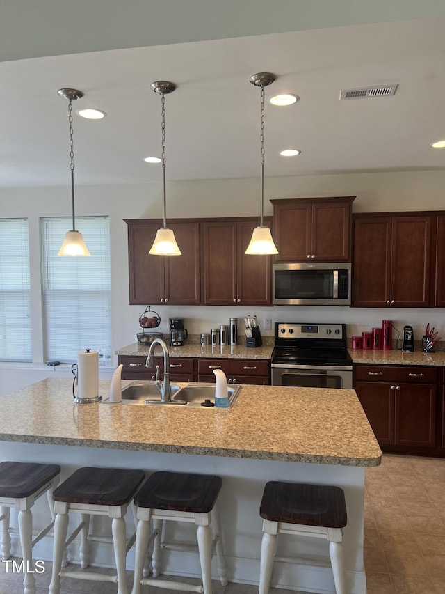 1565 Sage Treee Dr, Zebulon, NC 27597 - kitchen featuring stainless steel appliances, visible vents, a breakfast bar, and a sink