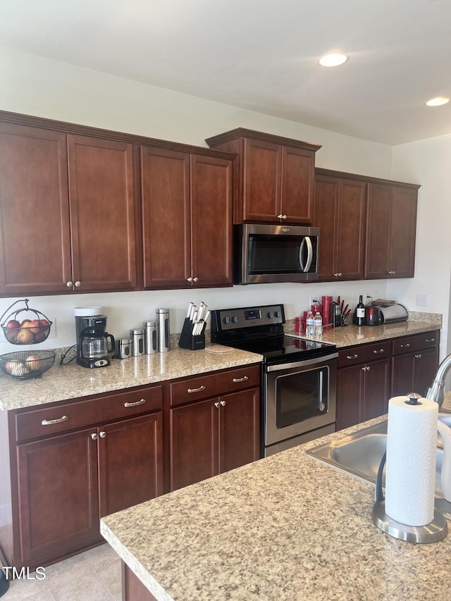 1565 Sage Treee Dr, Zebulon, NC 27597 - kitchen featuring recessed lighting, dark brown cabinetry, appliances with stainless steel finishes, and light tile patterned floors