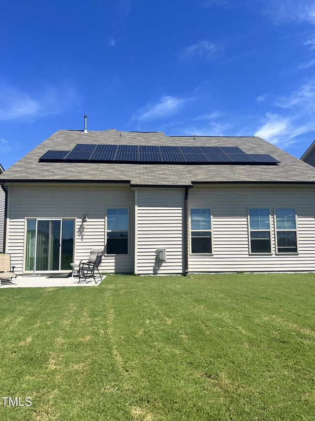 1565 Sage Treee Dr, Zebulon, NC 27597 - rear view of property with a lawn, roof mounted solar panels, and a patio area