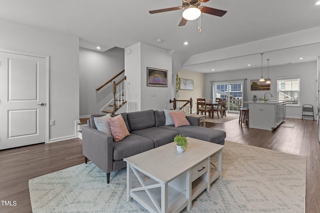 living room with ceiling fan, sink, and dark hardwood / wood-style floors