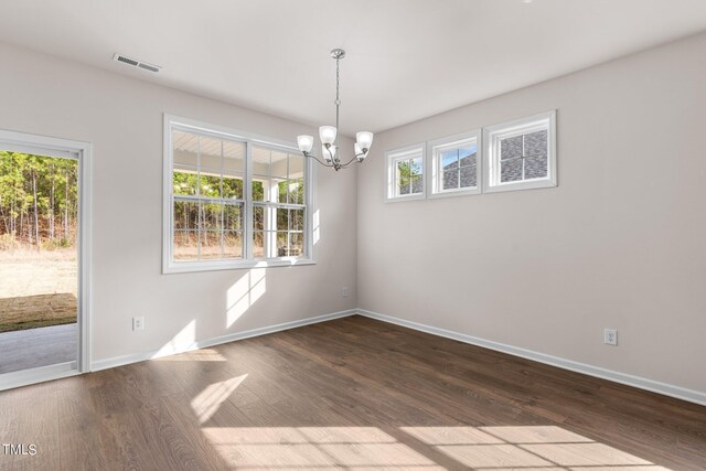 empty room featuring dark hardwood / wood-style floors and an inviting chandelier