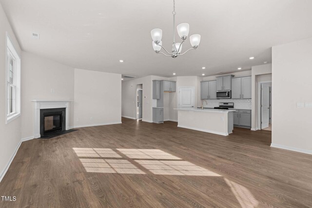 unfurnished living room featuring hardwood / wood-style floors and a chandelier