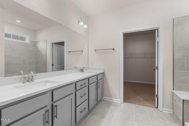 bathroom with tiled shower, vanity, and tile patterned floors