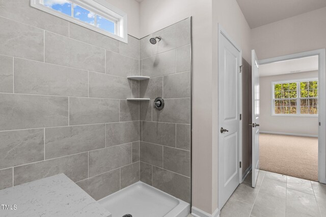 bathroom featuring tile patterned flooring and a tile shower