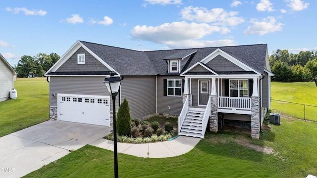 craftsman-style house featuring a garage, a front yard, a porch, and central air condition unit