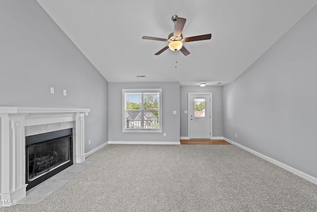 unfurnished living room featuring ceiling fan, a tiled fireplace, and light carpet