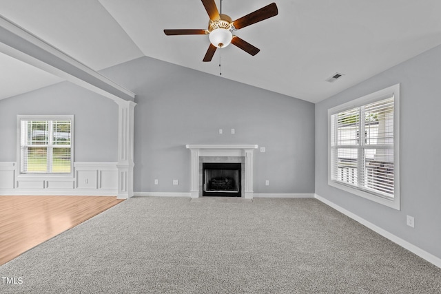 unfurnished living room featuring lofted ceiling, ceiling fan, a high end fireplace, and carpet floors