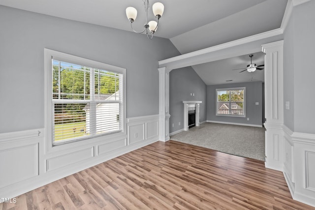 unfurnished living room with ceiling fan with notable chandelier, lofted ceiling, and hardwood / wood-style floors