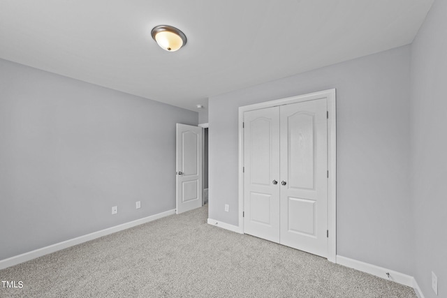 unfurnished bedroom featuring a closet and light carpet