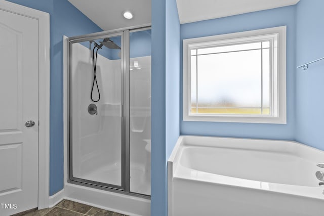 bathroom featuring a healthy amount of sunlight and separate shower and tub